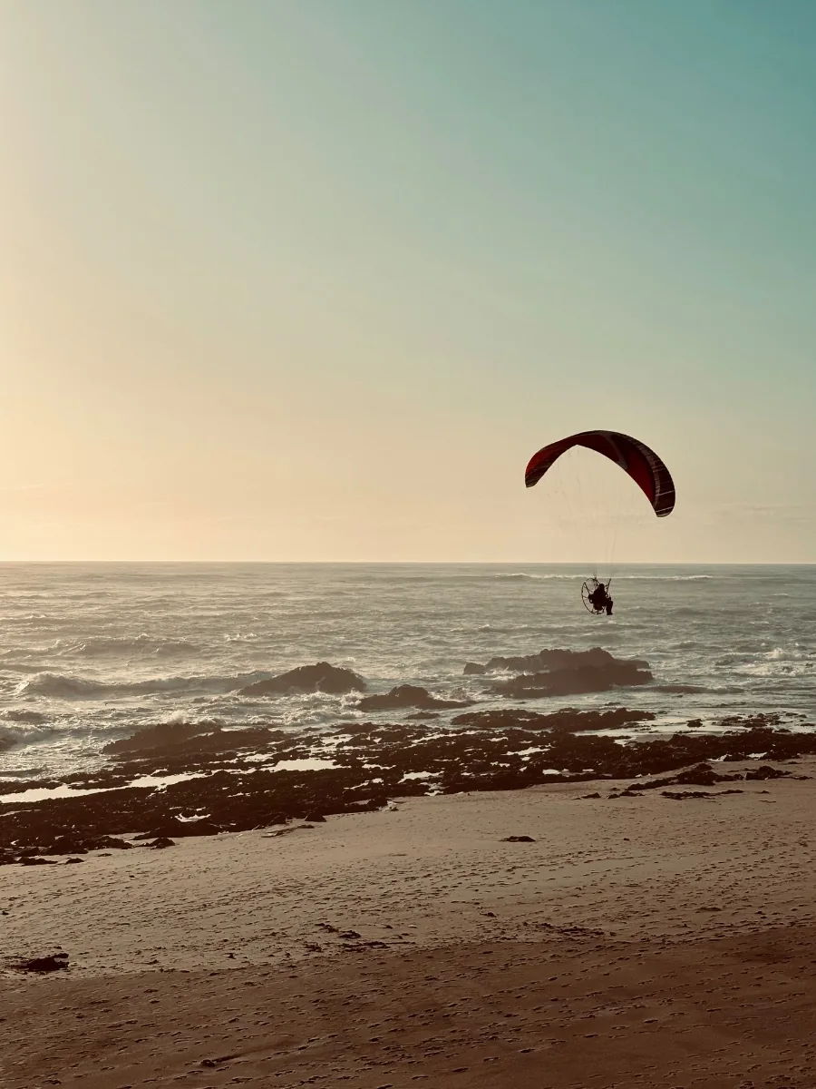 Paraglider over the beach at sunset